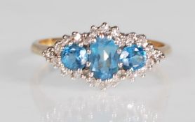 A hallmarked 9ct yellow gold ring set with a central oval faceted cut blue topaz flanked by two