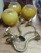 Three brass wall lamps with amber coloured glass shades