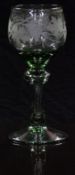 German green wine glass with engraved decoration of grapes on vines and knopped stem raised on