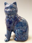 Ewenny pottery cat with separate front legs decorated in a mottled blue glaze, 18.5cm tall