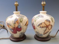 Moorcroft pair of table lamps decorated with butterflies and flowers, 28cm tall