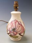 Moorcroft table lamp in Magnolia pattern on a cream ground, 26.5cm tall