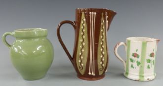 A 19th/20thC pottery lustre jug, Langollen slipware jug and a Brannum of Barnstaple jug, tallest