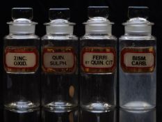 A set of four chemists/ pharmacy glass apothecary bottles with gilt labels including Bism Carb and