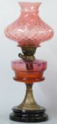 A late 19th / 20thC oil lamp with cranberry glass bowl and shade, 54cm tall