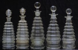 Five beehive shaped clear glass decanters each with spouted tops, largest 23cm tall.