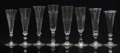 Eight 19thC and later glass champagne flutes or ale glasses, some with knopped stems, most with