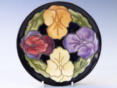 Moorcroft plate decorated with orchids on a black ground, diameter 16cm