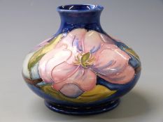 Moorcroft squat pedestal vase in Magnolia pattern on a blue ground, 11cm tall