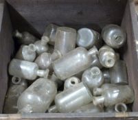 A large collection of apothecary style bottles in wooden crate
