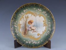 French porcelain charger hand decorated with a mother and baby with parasol beside a lake, signed