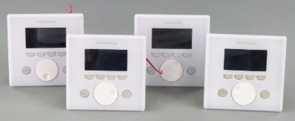 Four white Creston APAD wall mounted LCD controllers for Creston's Adagio home entertainment system,