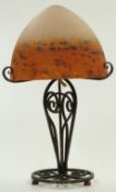 Degue mottled glass lamp raised on wrought iron base with scrolling decoration, 39cm tall.