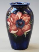 Moorcroft vase in Anemone pattern on a navy blue ground, 10.5cm tall