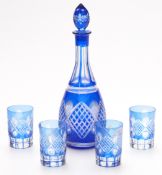 Flash overlaid cut glass drinking set comprising a decanter and four cups with blue overlay over a