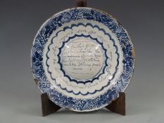 An 18thC Dutch Delft charger with unusual convex centre and Dutch script, dated 1783, diameter