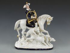 An exceptionally large Royal Dux figure of a huntsman on horseback with horn and three hounds,