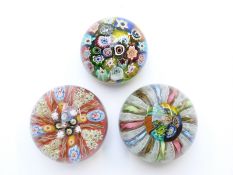 Three various glass paperweights, all with multi-coloured canes one with latticino and aventurine