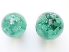 Two Nailsea green glass dump paperweights, both decorated with flowers, largest 9cm tall.