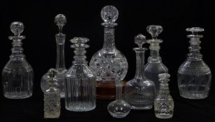 Ten various cut glass decanters including one on a wooden stand and three miniature examples,