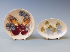 Moorcroft pin dishes decorated with a butterfly and flowers on a cream ground, largest signed J