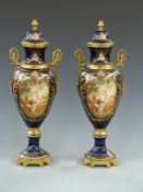 Pair of Sevres style twin handled covered pedestal vases with ormolu/brass mounts, decorated with