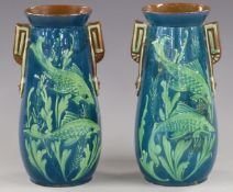 A pair of Watcombe Pottery twin-handled vases decorated with fish in relief, 25cm tall