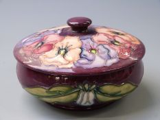 Moorcroft lidded pedestal powder dish in Pansy pattern on a magenta ground, 6cm tall, diameter 12.