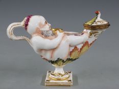 Naples/Capodimonte figural pedestal inkwell in the form of a man holding a bowl, with hinged lid and