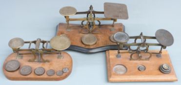 Three sets of Victorian brass postage scales, one with Avery weights, width of largest 25cm