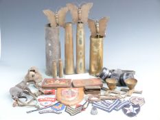 An assortment of militaria to include trench art, cloth insignia, South Africa 1900 tin etc