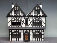 A large three-storey dolls' house with removeable fronts, hand-made by F Hibberd of Gloucester,
