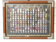 A framed set of Danbury Mint reproduction British Gallantry and Campaign miniature medals, with