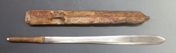 A tribal machete with leather covered wooden scabbard, blade length 40cm