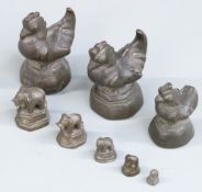 Three bronze or similar opium weights formed as cockerels, together with a smaller set formed as