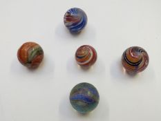Five very large handmade glass marbles one with pink, blue and white central core surrounded by