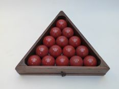Set of red snooker or billiard balls in wooden triangle with removable box
