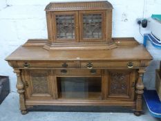 Art Nouveau oak sideboard with bevelled astragal glazed cabinet to top, the base fitted three