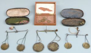 Three cased sets of travelling beam scales including apothecary and similar weights