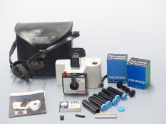 Polaroid Swinger Model 20 camera together with a quantity of accessories