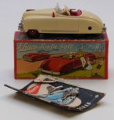 Schuco Radio 4012 clockwork tinplate car car with cream body and red interior containing a Thorens