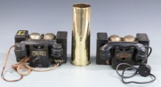 A pair of military field telephones and a WWI artillery shell case dated 1915