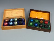 Two cased sets of Monmouthshire County Council egg grading test poises, one set with plaque to lid