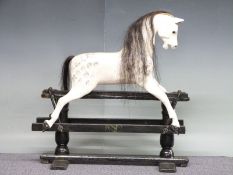 A wooden rocking horse in dapple grey on black base, 88cm long x 88cm tall