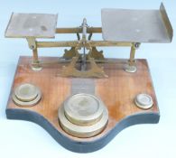 Victorian brass parcel scales on wooden base with flat stacking weights from 4lb down to 2oz,