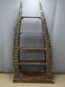 Indian or similar Eastern bookcase, the vertical support formed from horse hames with brass and