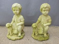 A pair of garden figures of boys with dogs, height 46cm