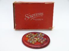 Thirty-two glass marbles all with multi-coloured twists each approximately 15mm in diameter, on a