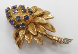 An 18ct gold brooch in the form of a stylised palm tree set with sapphires with a diamond to the