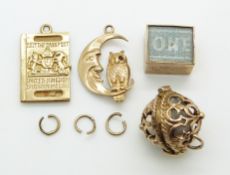A 9ct gold passport charm/ pendant, a 9ct gold compass charm/ pendant, a 9ct gold moon and owl